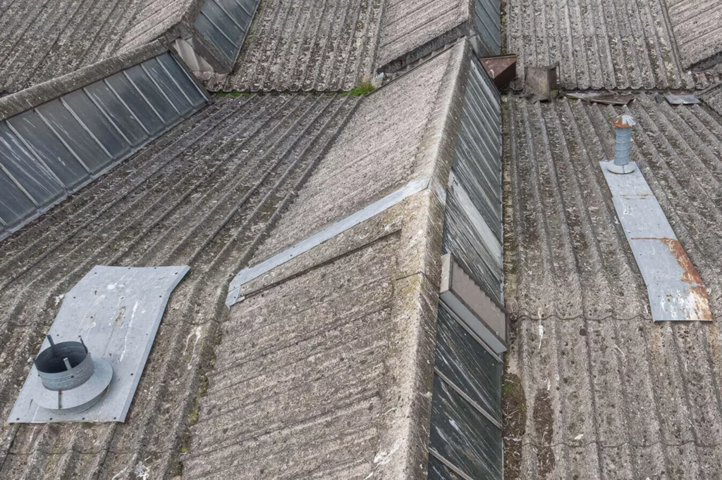 Drone survey inspection of asbestos industrial roof showing defective outlets and debris on corrugated sheeting